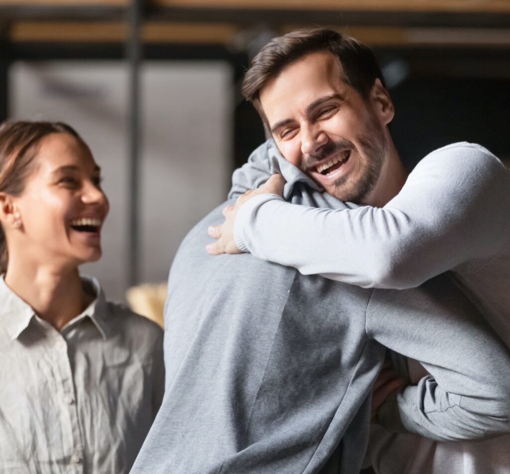 Young man hugging another man