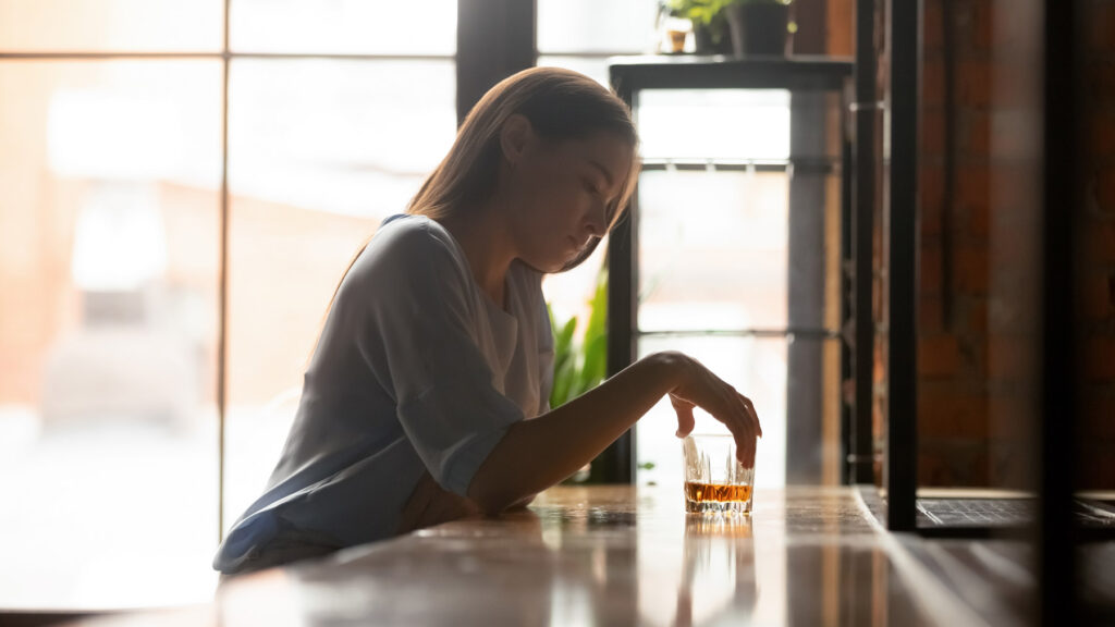 Depressed woman drinking at bar