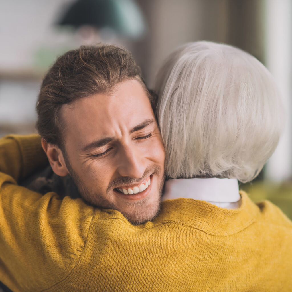 Son smiling hugging his mother