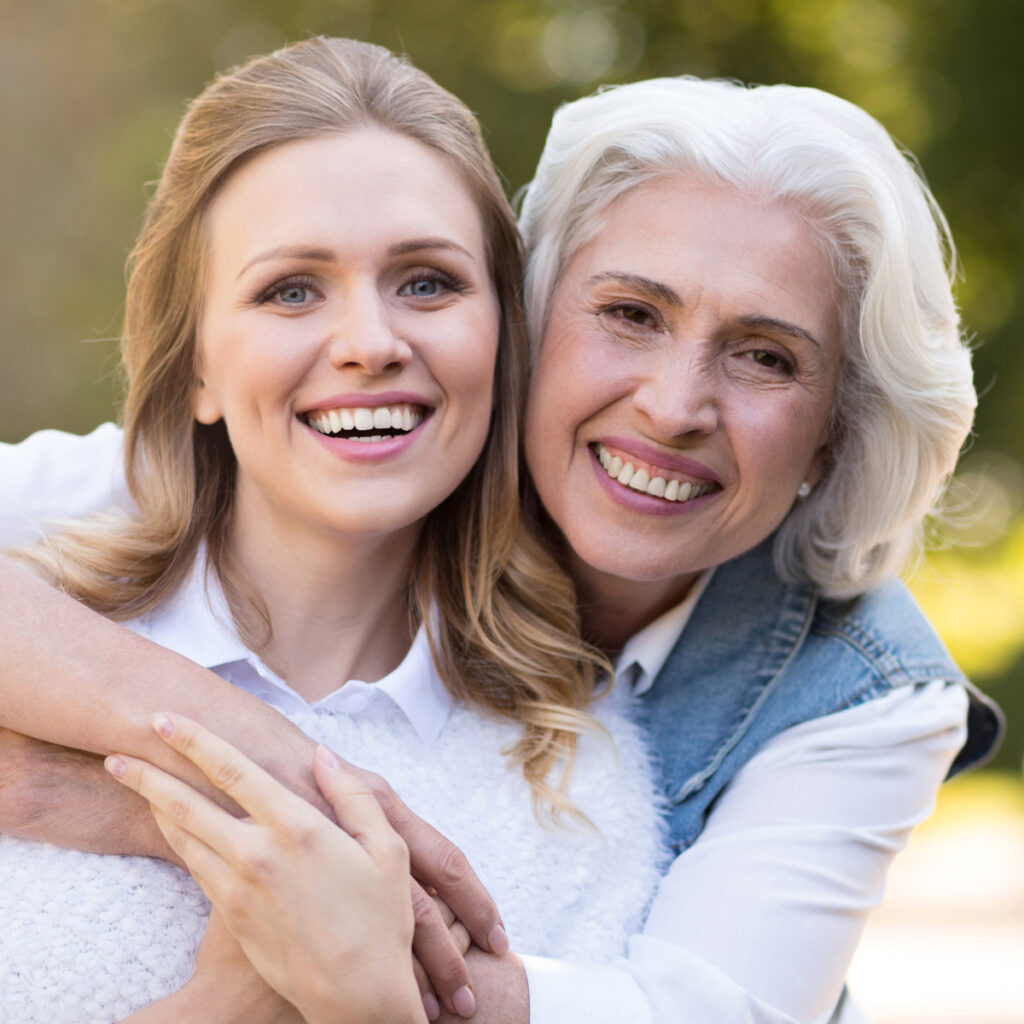 Mother and daughter smiling outdoors